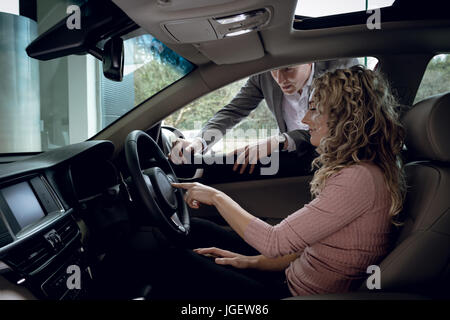 Vendeur expliquant au client sitting in car Banque D'Images