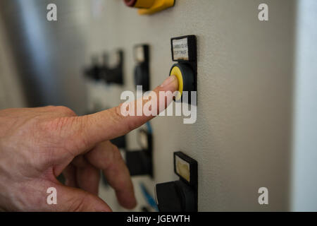 Part en appuyant sur un bouton de commande à l'usine Banque D'Images