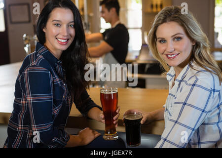 Portrait of smiling woman holding drinks bartender avec en arrière-plan au restaurant Banque D'Images
