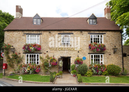 Le Greyhound Pub, Wooton, Oxfordshire en été avec des fleurs et des corbeilles suspendues ; Oxfordshire England UK Banque D'Images