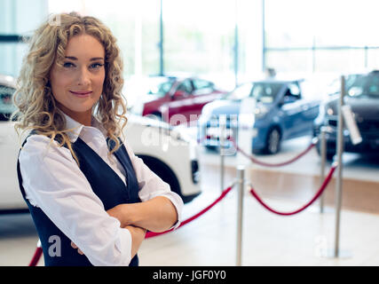 Portrait of smiling saleswoman standing in showroom Banque D'Images