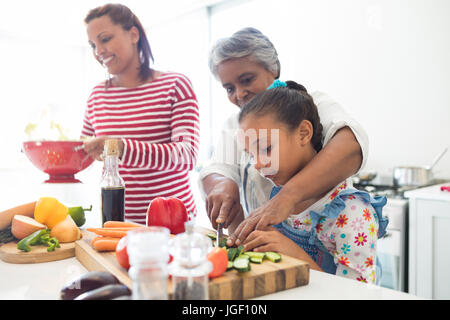 Aider grand-mère à petite-fille couper les légumes dans la cuisine à la maison Banque D'Images