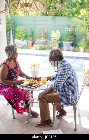 High angle view of couple having breakfast at table in yard Banque D'Images