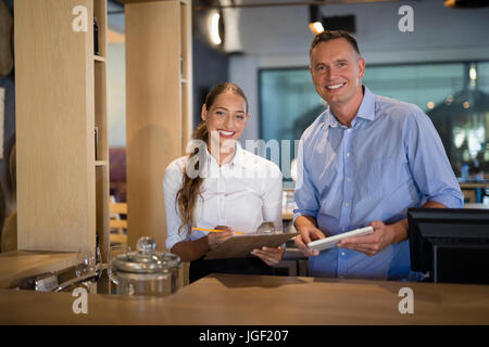 Portrait of smiling manager et le barman debout à comptoir bar Banque D'Images