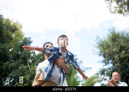 Low angle view of man looking at père jouant avec son at park against sky Banque D'Images