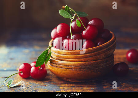 Les cerises dans un bol sur une table en bois. Cerises fraîchement récoltées dans un bol sur une table en bois. Banque D'Images