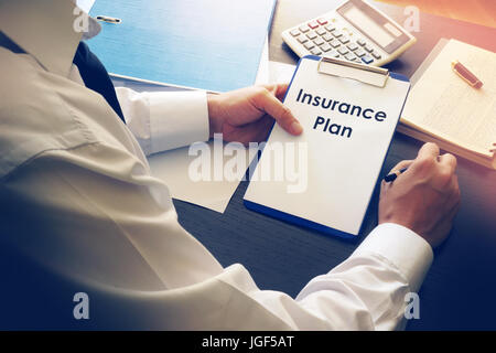 Travaillant dans un bureau table avec plan d'assurance. Banque D'Images