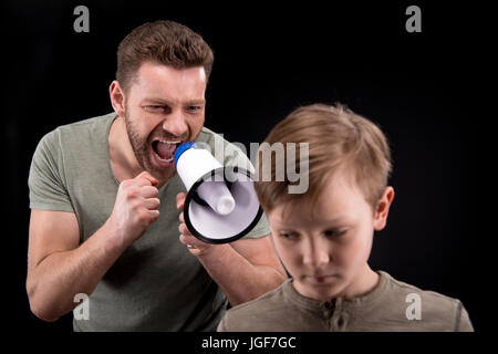 Père avec mégaphone hurler à peur petit fils, les problèmes de famille concept Banque D'Images