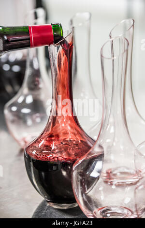 Sommelier au travail, de verser le vin à la carafe en position debout près de l'Étagère à vin, Diner De Luxe Banque D'Images