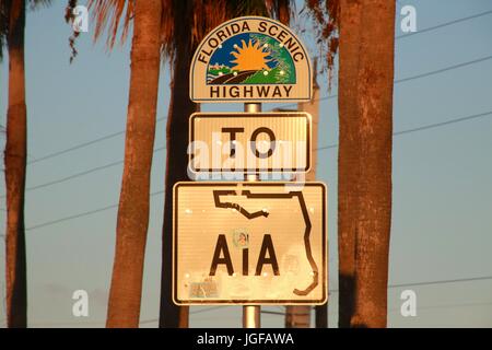 La route panoramique de la Floride à A1A signer au coucher du soleil, encadré par deux troncs de palmiers Banque D'Images