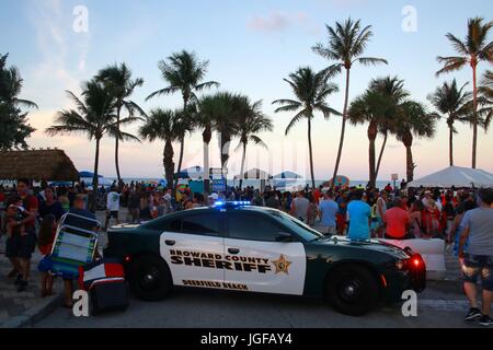 Le comté de Broward Sheriff Voiture de police Lights clignotant à Deerfield Beach, en Floride, après le coucher du soleil en face de barricades et foule de personnes, le 4 juillet 2017 Banque D'Images
