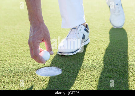 Portrait de la récupération de balle de golf de trou sur golf Banque D'Images