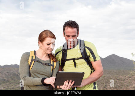 Les randonneurs using digital tablet in desert Banque D'Images