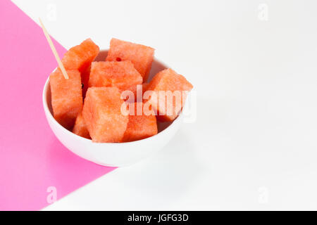 Watermelon chuncks dans un bol blanc, fond bicolore. Banque D'Images
