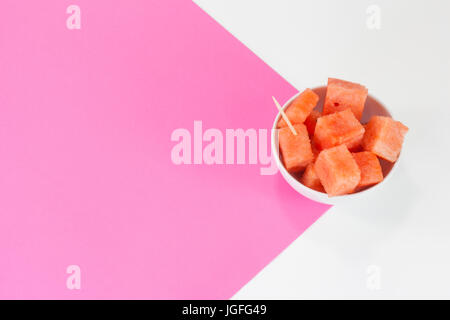 Watermelon chuncks dans un bol blanc, fond bicolore. Banque D'Images