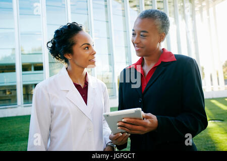 Médecin et administrateur à l'extérieur à l'hôpital using digital tablet Banque D'Images