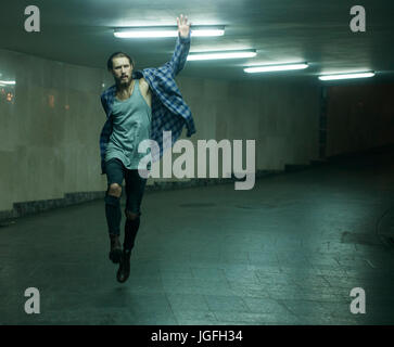 Carefree woman skipping in tunnel Banque D'Images