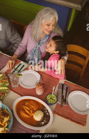 Portrait de grand-mère en petite-fille étreindre restaurant Banque D'Images