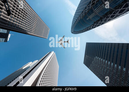 Bâtiments gratte-ciel de Tokyo et d'un avion volant au-dessus du centre-ville de Shinjuku à Tokyo, dans le quartier des affaires dans la région de matin à Tokyo, Japon. Banque D'Images