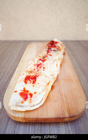 Pizza Calzone sur planche de bois vue avant Banque D'Images