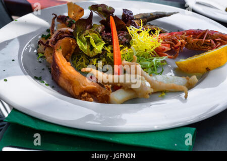 Libre de divers genres de poisson grillé sur une plaque blanche dans le restaurant. Banque D'Images