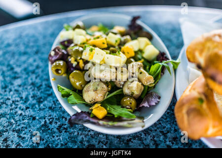 Gros plan macro de salade sur la plaque dans le aux champignons, fromage, olives et carrés verts Banque D'Images