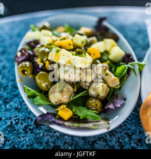 Gros plan macro de salade sur la plaque dans le aux champignons, fromage, olives et carrés verts Banque D'Images