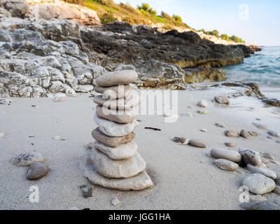 Tour de cailloux sur une plage de sable fin Banque D'Images