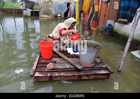 Dhaka, Bangladesh. 7e juillet, 2017. Une femme bangladaise à laver les vêtements dans une maison inondée au barrage du MDN à Dhaka, au Bangladesh. L'empiètement des canaux est de contribuer à l'accumulation d'eau dans la région. Credit : SK Hasan Ali/Alamy Live News Banque D'Images