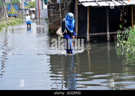 Dhaka, Bangladesh. 7e juillet, 2017. Peuple bangladais traverser une rue inondée au barrage du MDN à Dhaka, au Bangladesh. L'empiètement des canaux est de contribuer à l'accumulation d'eau dans la région. Credit : SK Hasan Ali/Alamy Live News Banque D'Images