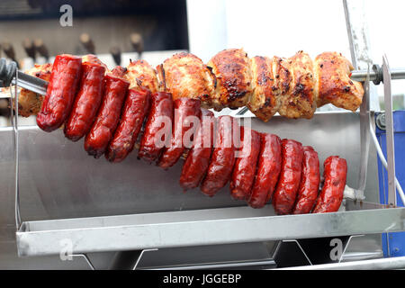 Et saucisses chorizo poulet rôti sur un charbon Spit barbecues torréfacteur Banque D'Images