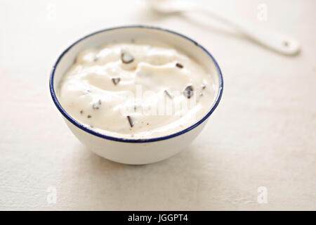 Yaourt Stracciatella dans un petit bol avec cuillère blanc Banque D'Images