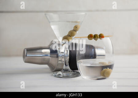 Olives vertes en vodka martini avec shaker sur table en bois Banque D'Images