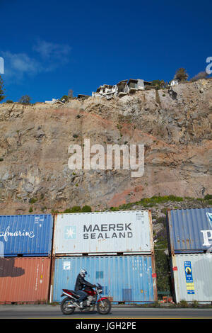 Clifftop house endommagé par un tremblement de terre, et des conteneurs d'expédition de la protection de la circulation à partir de la chute de débris, Sumner, Christchurch, Canterbury, île du Sud, Banque D'Images