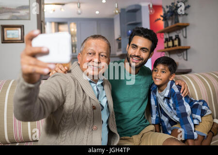 En famille tout en selfies sitting on sofa at home Banque D'Images