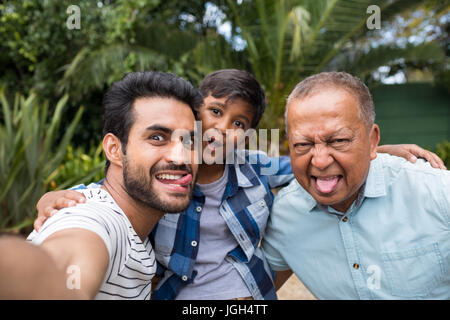 Close up of family making faces debout contre des plantes du park Banque D'Images