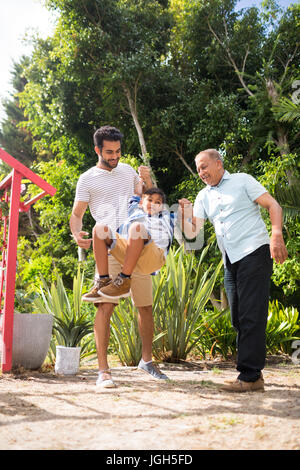 Père et grand-père ludique avec boy au parc en journée ensoleillée Banque D'Images