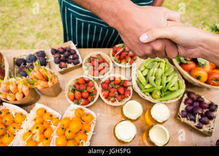 Portrait of female customer shaking hand with man vente de fruits à la ferme Banque D'Images