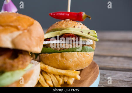 Close up of burger avec piment jalapeno et frites on cutting board Banque D'Images