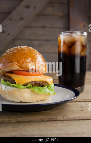 Hamburger en plaque avec verre de boisson froide sur la table Banque D'Images