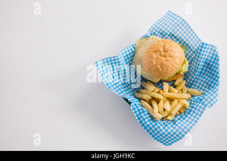 Tourné directement au-dessus de burger et frites en serviette sur le tableau blanc Banque D'Images