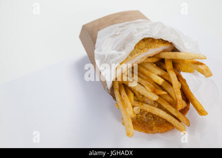 Close-up of French Fried chips dans un sac en papier à emporter sur fond blanc Banque D'Images