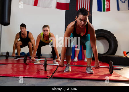 Portrait de femme athlète barbell levage avec des amis au studio de remise en forme Banque D'Images