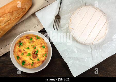 Une photo prise à la verticale du Français produits alimentaires avec une place pour le texte. Une baguette, une quiche, et un chef de camembert, tourné par le haut avec un élégant Banque D'Images