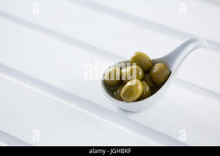 Close-up of olives vertes marinées dans une cuillère sur la table Banque D'Images