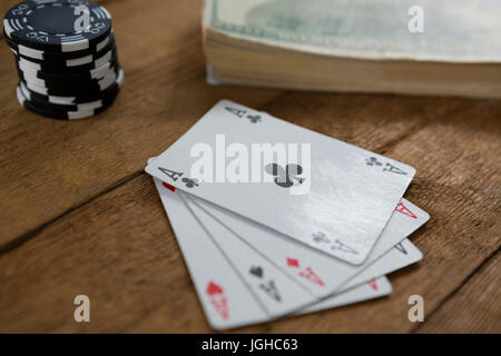 Close-up de quatre as par plaquettes et de l'argent sur la table en bois Banque D'Images