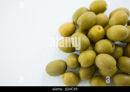 Close-up of olives vertes marinées against white background Banque D'Images