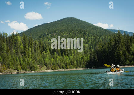 Vue arrière de l'âge mûr kayak dans le lac par mountain against sky Banque D'Images