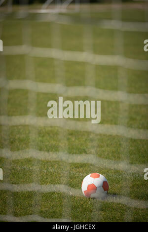 Ballon de football sur terrain de jeu vu grâce à net Banque D'Images