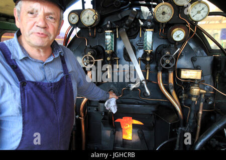 Le chemin de fer à vapeur du patrimoine, Sheringham Park, North Norfolk, Angleterre, RU de fer à bord conducteur machine à vapeur avec feu de charbon Banque D'Images